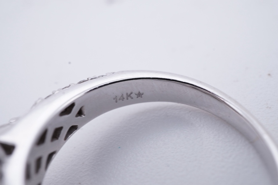 A diamond ring, centring on a tessellated arrangement of princess-cut and triangular diamonds totalling approximately 0.50 carats, to a border and band pavé-set with brilliant-cut diamonds, the shoulders accented with ad